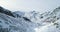 Forward aerial over winter snowy mountain pass with mountaineering skier people walking up climbing.snow covered