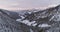 Forward aerial to snowy valley with woods forest at Sella pass.Sunset or sunrise,cloudy sky.Winter Dolomites Italian