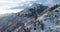 Forward aerial top view over car travelling on road in Winter snow mountain near forest woods.Snowy mountains street