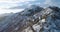 Forward aerial top view over car travelling on road in Winter snow mountain near forest woods.Snowy mountains street