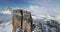 Forward aerial toward majestic Cinque Torri mounts showing steep rocky cliff. Sunny day with cloudy sky.Winter Dolomites