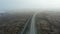 Forward flight aerial view over breathtaking and surreal Icelandic landscape with car driving on Ring Road. Calm and