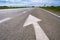 Forward igns on the road. White painting in turn left direction arrow symbol on black asphalt road background and against the blue