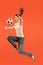 Forward to the victory.The young woman as soccer football player jumping and kicking the ball at studio on a red