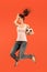 Forward to the victory.The young woman as soccer football player jumping and kicking the ball at studio on a red