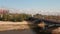 Forwards ascending fly above Vistula river along Poniatowski Bridge with road traffic. Modern National stadium on side