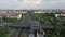 Forwards fly above multi track railway line with train station. Tracking of S bahn train arriving into station under