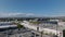 Forwards fly above town development in Culver City. Low buildings and downtown skyscrapers in distance. Los Angeles