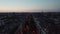 Forwards fly above wide and straight street in city. View against colourful twilight sky. Berlin, Germany