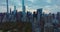 Forwards fly along autumn Central park at dusk. Aerial footage of high rise buildings in downtown surrounding park