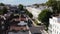 Forwards fly over row of houses. Big white town houses lit by bright sun. Elevated view of street in residential borough