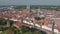Forwards fly to historic brick buildings in medieval city centre. Aerial view of Trave river waterfront street with