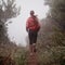 She found the path to longevity. Rearview shot of a woman running on a trail on a misty morning.