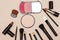 Foundation powder and three color blush, variety lipstick and lip gloss, mascara brush on wood table