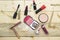Foundation powder and three color blush, variety lipstick and lip gloss, mascara brush on wood table.