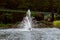 A fountain in an artificial pond with waves.