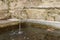 A fountain drips into a stone tank in an Alpine village