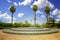 Fountain near Koutoubia Mosque minaret at medina quarter of Marrakesh, Morocco. There is beautiful green garden with palms. Blue