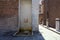 Fountain shaped as a face in a palace next to an alley in an italian town on a sunny day