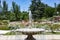 Fountain. Stone fountain filled with water with an explosion of spring with colorful flowers in the entire park of Madrid