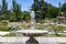 Fountain. Stone fountain filled with water with an explosion of spring with colorful flowers in the entire park of Madrid