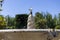 Fountain. Stone fountain filled with water with a jet of water at its tip in a park in Madrid on a clear day with a blue sky