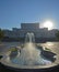 Fountain on Unirii Boulevard with Parliament and evening sun as background