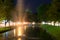 Fountain in water canal with nighttime light.