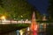 Fountain in water canal with nighttime light.