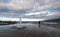 Fountain with water round ripples and a man looking at sea with surfers.