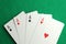 Four aces playing cards on green table, top view. Poker game