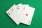 Four aces playing cards on green table, top view. Poker game