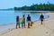 Four african black women on an amazing tropical beach holding fishing nets ready for a day of hard work in the ocean