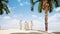 Four Arab men are talking on the beach with palm trees.