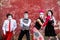 Four armed mimes standing on a red wall.