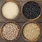 Four assorted grains in bowls over wooden background