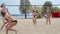 Four athletic women are playing volleyball on the beach, outdoor sports, 4k