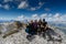 Four attractive women mountain climbers hug and smile on a mountain peak after a hard climb together