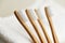 Four bamboo toothbrushes on white towel