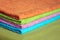 Four bath towels of different colors stacked closeup