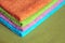 Four bath towels of different colors stacked closeup