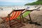 Four beach armchair with leather slippers with tourists on sandy beach