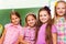 Four beautiful girls stand close in classroom