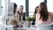 Four beautiful smart business women work with laptops on the desk while talking in the coworking space in the office.