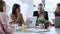 Four beautiful smart business women work with laptops on the desk while talking in the coworking space in the office.