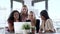 Four beautiful smart business women working with laptop and digital tablet on the desk while talking in the coworking spa