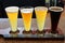 Four beer samplers set in wooden tray for craft beer lovers to try out and vote on