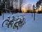 Four bicycles under snow on a parking on winter evening
