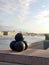 Four black cannonballs on the embankment of the Neva river. In the background, the river, houses, cloudy sky