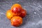 Four blood red oranges on a dark background.